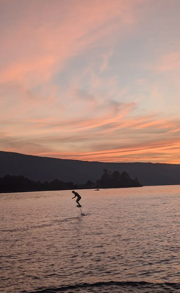 Rider en pump foil au coucher du soleil sur le lac